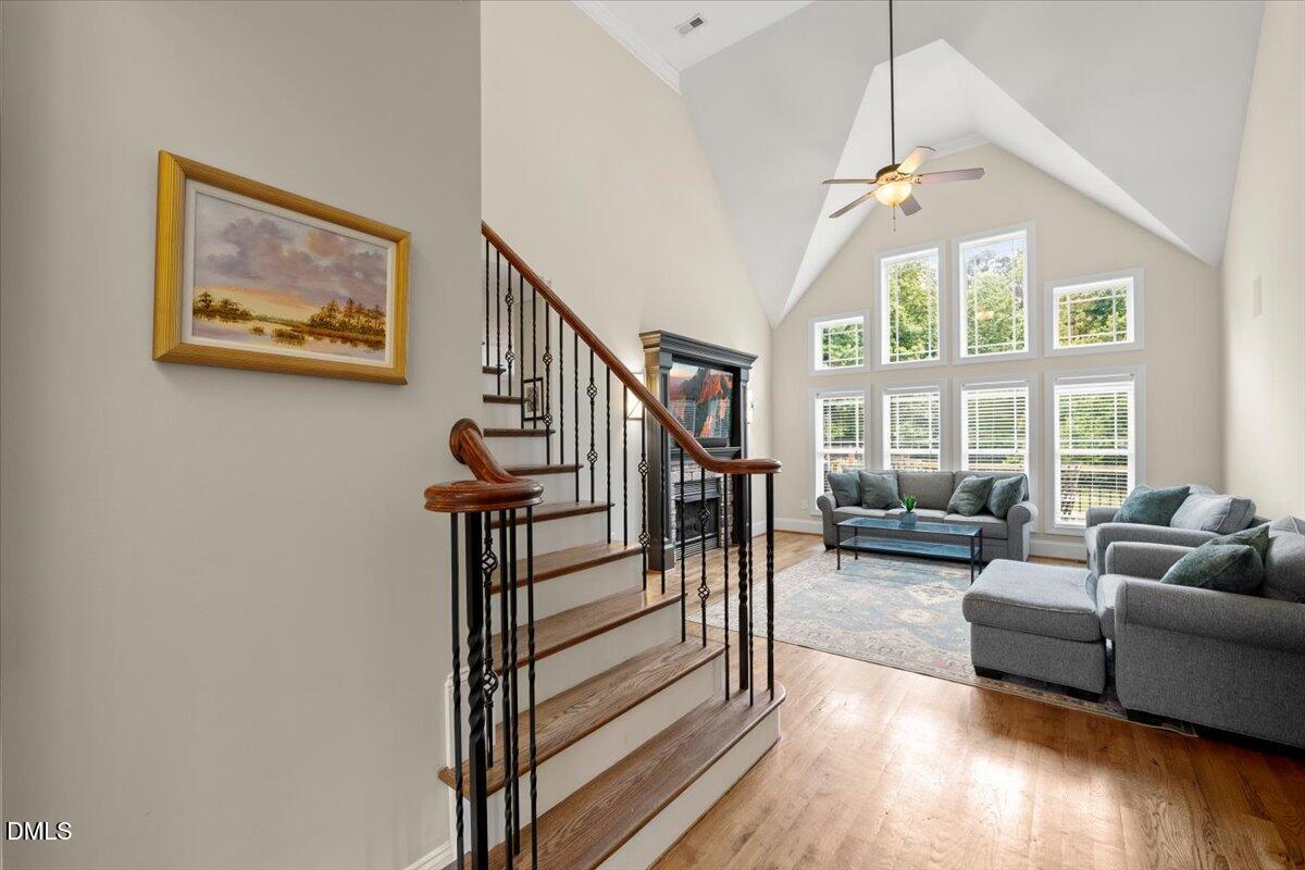 7400 Denlee Road Raleigh, NC 27603 - Photo 9 of 47 a living room with furniture a fireplace and a floor to ceiling window