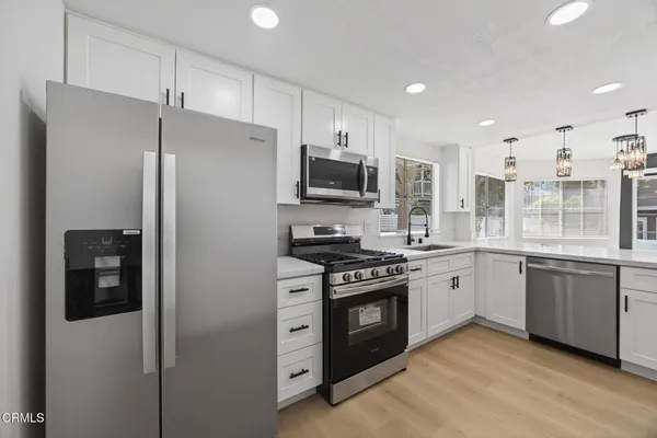 a kitchen with stainless steel appliances granite countertop a stove a refrigerator and a sink