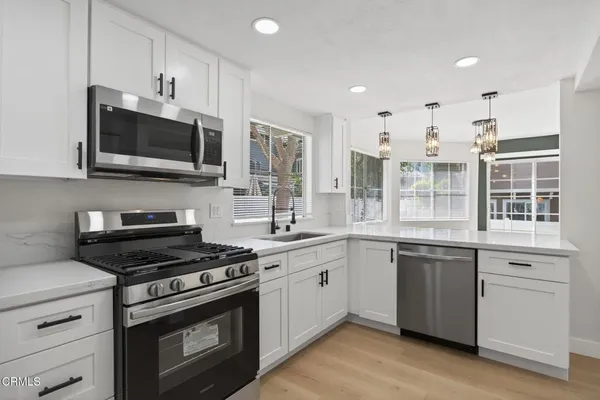 a kitchen with stainless steel appliances a stove sink microwave and cabinets