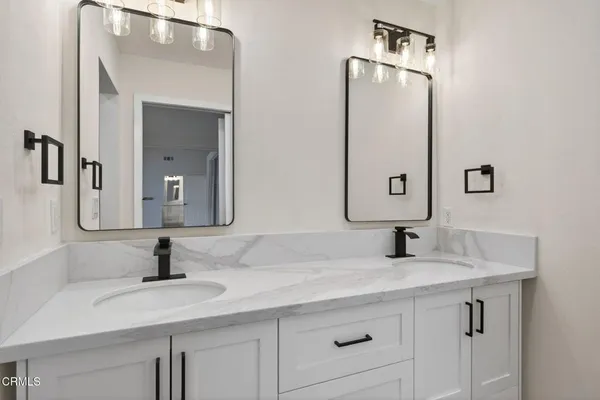 a bathroom with double vanity sinks and a mirror
