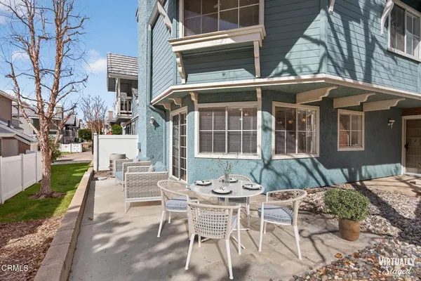 a view of a patio with couches table and chairs and potted plants