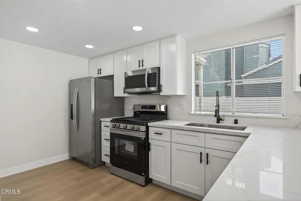 a kitchen with a sink stove and refrigerator