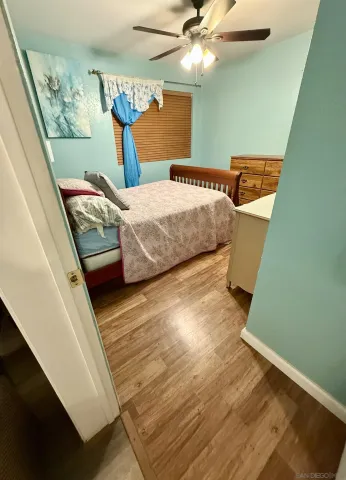 a bedroom with a bed and wooden floor