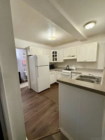 a kitchen with a sink a refrigerator a microwave and cabinets