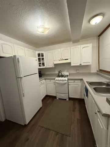 a kitchen with a sink a refrigerator a microwave and cabinets