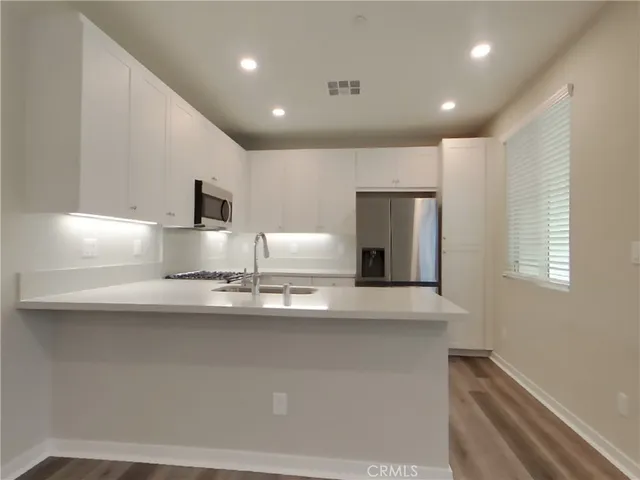 a kitchen with stainless steel appliances a sink stove and refrigerator
