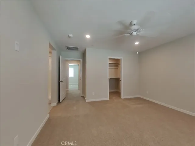 an empty room with fan and entrance