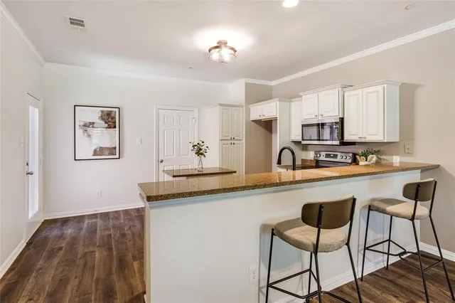 a kitchen with stainless steel appliances granite countertop a stove a sink and a refrigerator