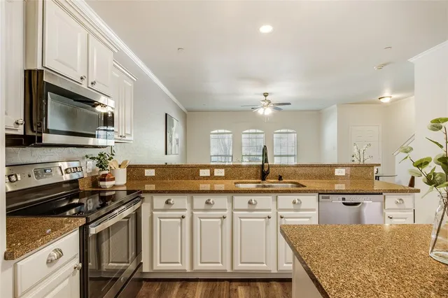 a kitchen with stainless steel appliances granite countertop a stove a sink and a microwave