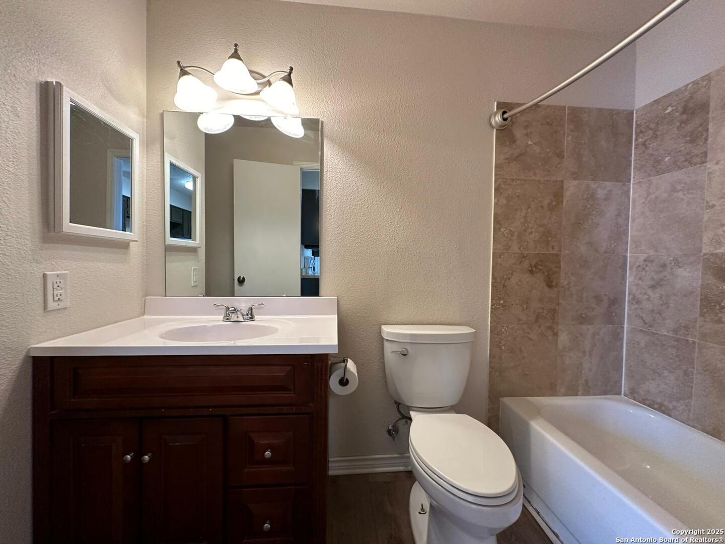 4949 Hamilton Wolfe Road, Unit 8201 San Antonio, TX 78229 - Photo 11 of 16 a bathroom with a toilet a sink a large mirror and shower