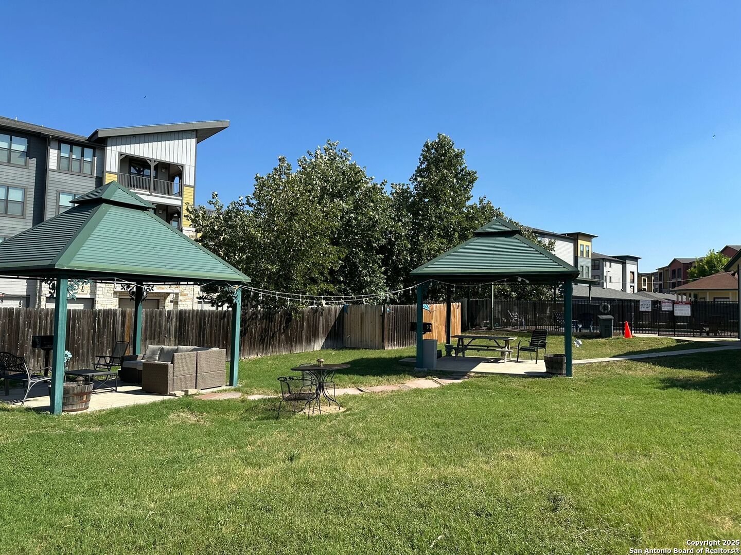 4949 Hamilton Wolfe Road, Unit 8201 San Antonio, TX 78229 - Photo 15 of 16 a backyard of a house with barbeque oven table and chairs