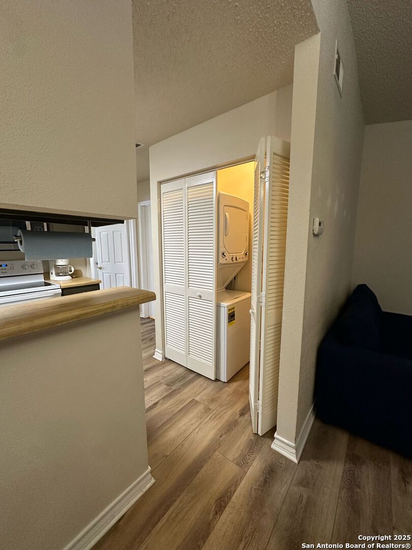 4949 Hamilton Wolfe Road, Unit 8201 San Antonio, TX 78229 - Photo 5 of 16 a kitchen with granite countertop a refrigerator and a sink