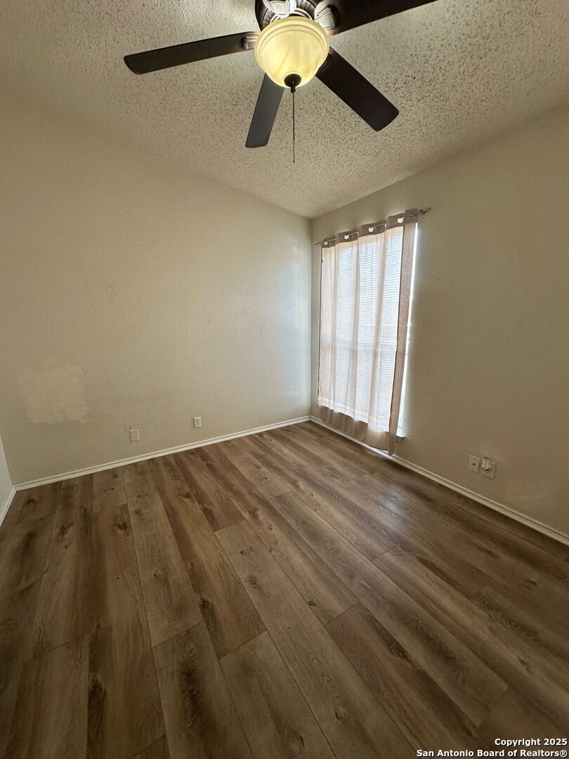 4949 Hamilton Wolfe Road, Unit 8201 San Antonio, TX 78229 - Photo 10 of 16 wooden floor in an empty room with a window
