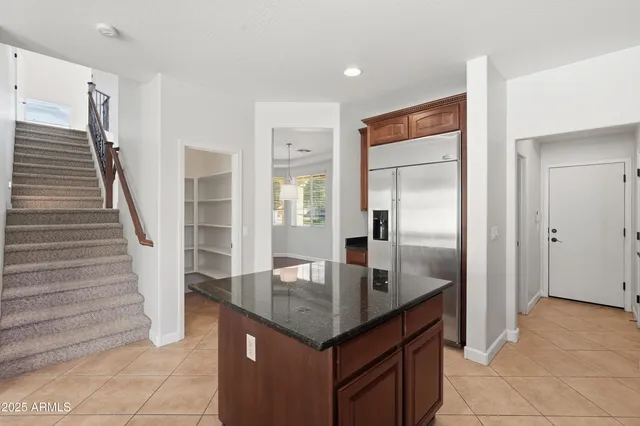 a kitchen with granite countertop a sink and refrigerator