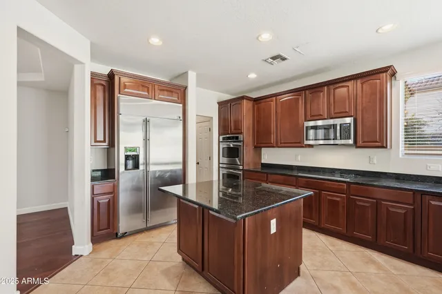a kitchen with stainless steel appliances granite countertop a stove a refrigerator and a sink