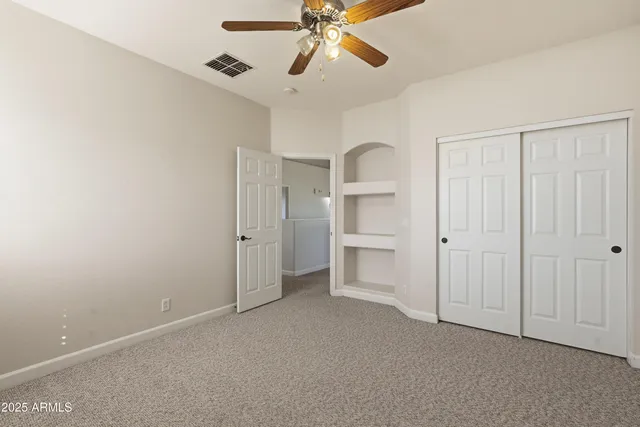 a view of a closet area with ceiling fan