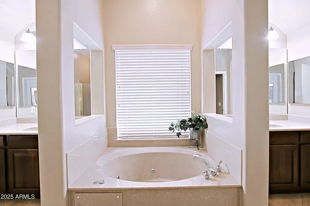 a white bath tub sitting in a en suite bathroom next to a window