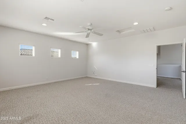 an empty room with a ceiling fan and a window