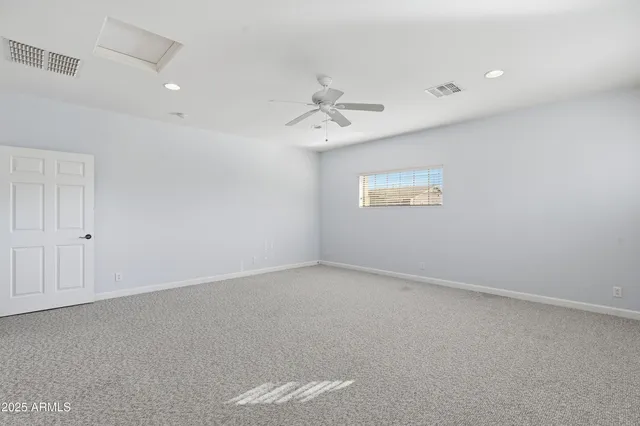an empty room with a window and a ceiling fan