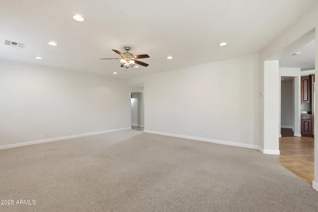 an empty room with a ceiling fan and a window