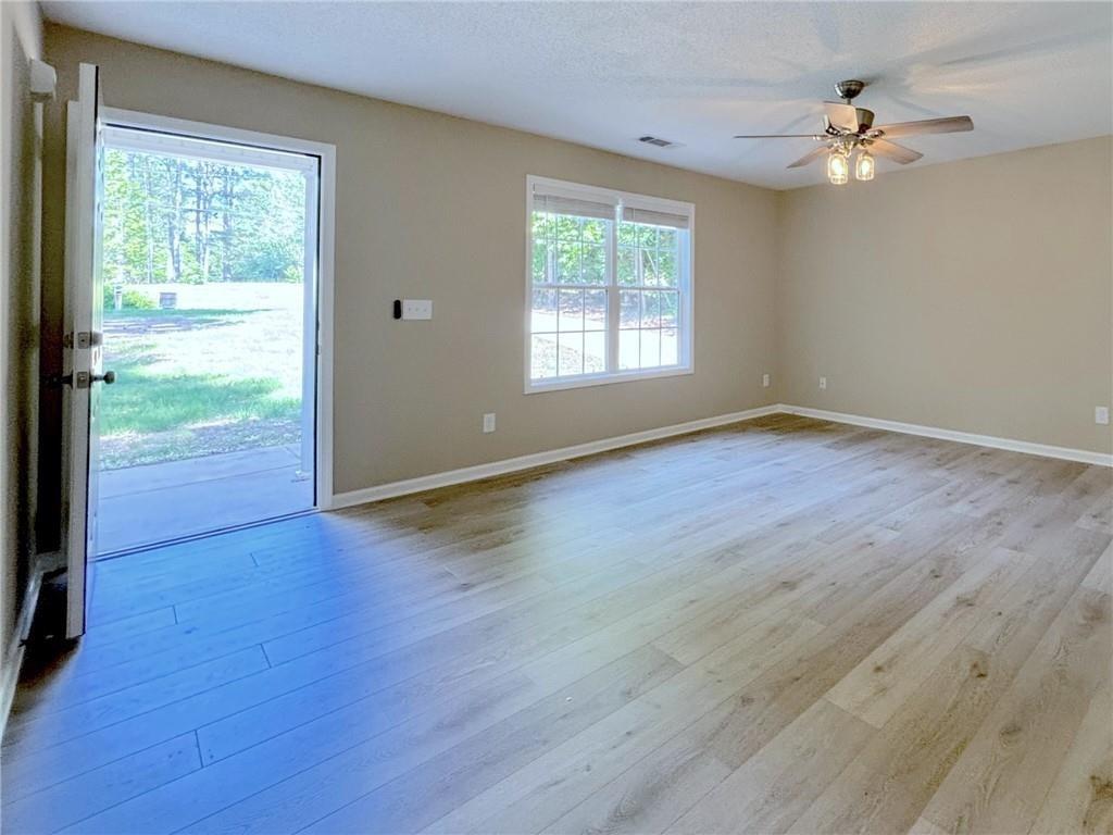 413 Old Brock Road Rockmart, GA 30153 - Photo 12 of 27 an empty room with wooden floor chandelier fan and windows