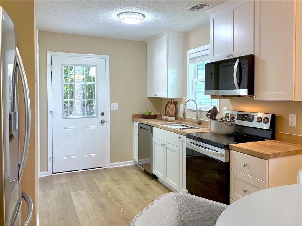 413 Old Brock Road Rockmart, GA 30153 - Photo 5 of 27 a kitchen with stainless steel appliances granite countertop a stove a sink and a refrigerator