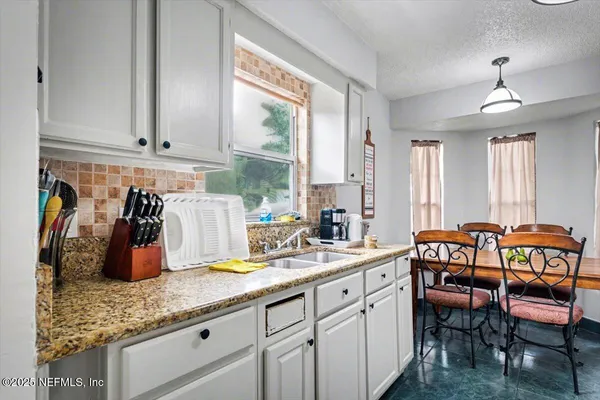 a kitchen with sink and view living room