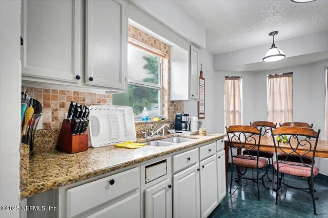 a kitchen with sink and view living room