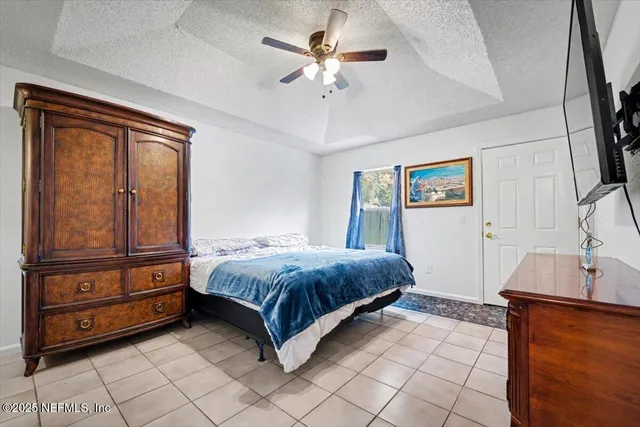 a spacious bedroom with a bed and a chandelier