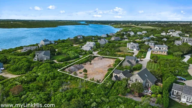 an aerial view of a house with a yard lake and outdoor seating