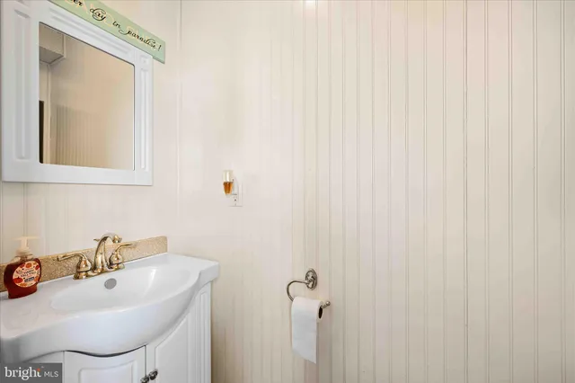 front view of a house with a yard deck and a large tree