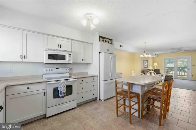a kitchen with cabinets appliances a sink and a window
