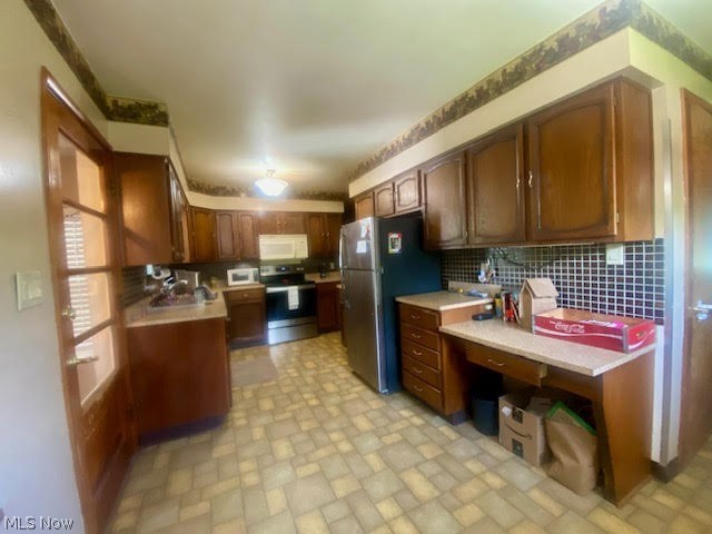 3565 Palmyra Road Southwest Warren, OH 44481 - Photo 7 of 31 Kitchen with sink, light tile floors, backsplash, and appliances with stainless steel finishes