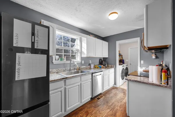 a kitchen with a sink a refrigerator and cabinets