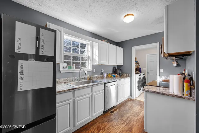 a kitchen with a sink a refrigerator and cabinets
