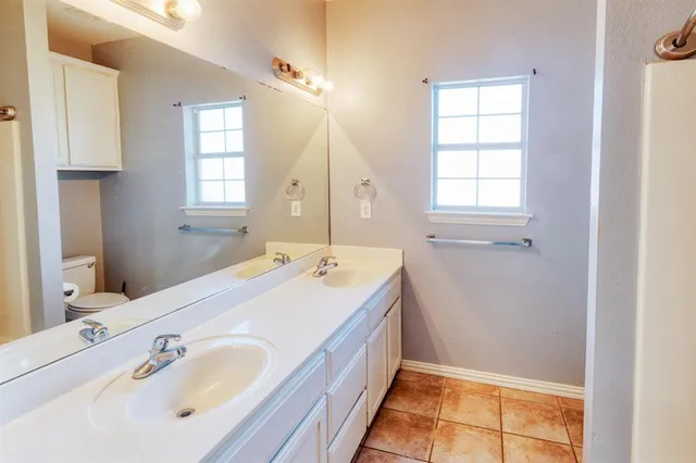 a spacious bathroom with a tub sink and mirror
