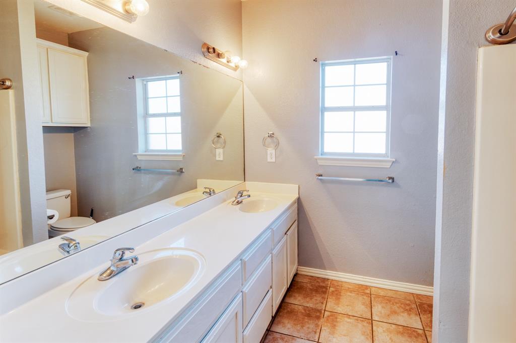 216 East Walcott Street Pilot Point, TX 76258 - Photo 8 of 12 a spacious bathroom with a tub sink and mirror