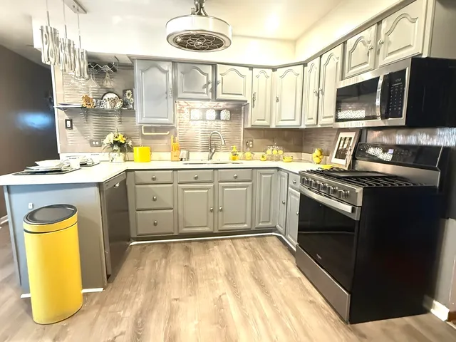 a kitchen with stainless steel appliances granite countertop a sink a stove and a microwave