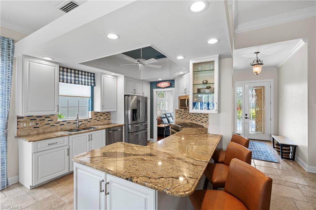 4401 Novato Court Naples, FL 34109 - Photo 14 of 50 a kitchen with stainless steel appliances granite countertop a sink dishwasher stove and refrigerator