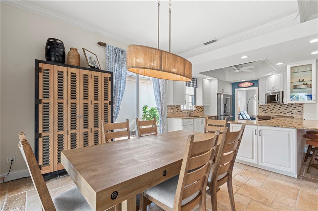 4401 Novato Court Naples, FL 34109 - Photo 19 of 50 a dining room with stainless steel appliances furniture large window and wooden floor