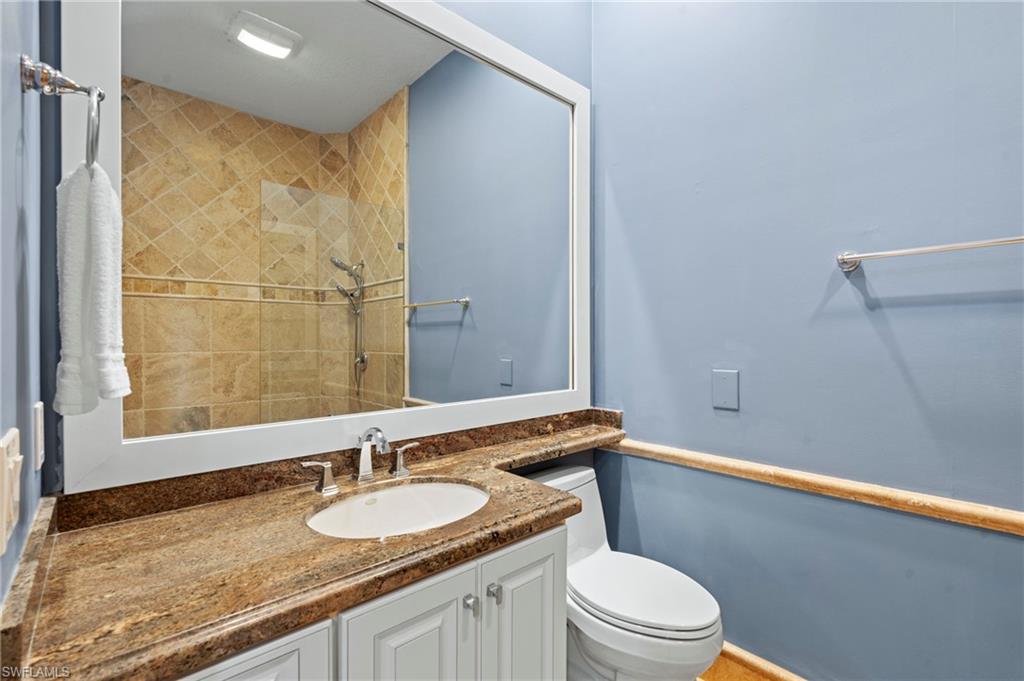 4401 Novato Court Naples, FL 34109 - Photo 25 of 50 a bathroom with a granite countertop sink a mirror and a toilet