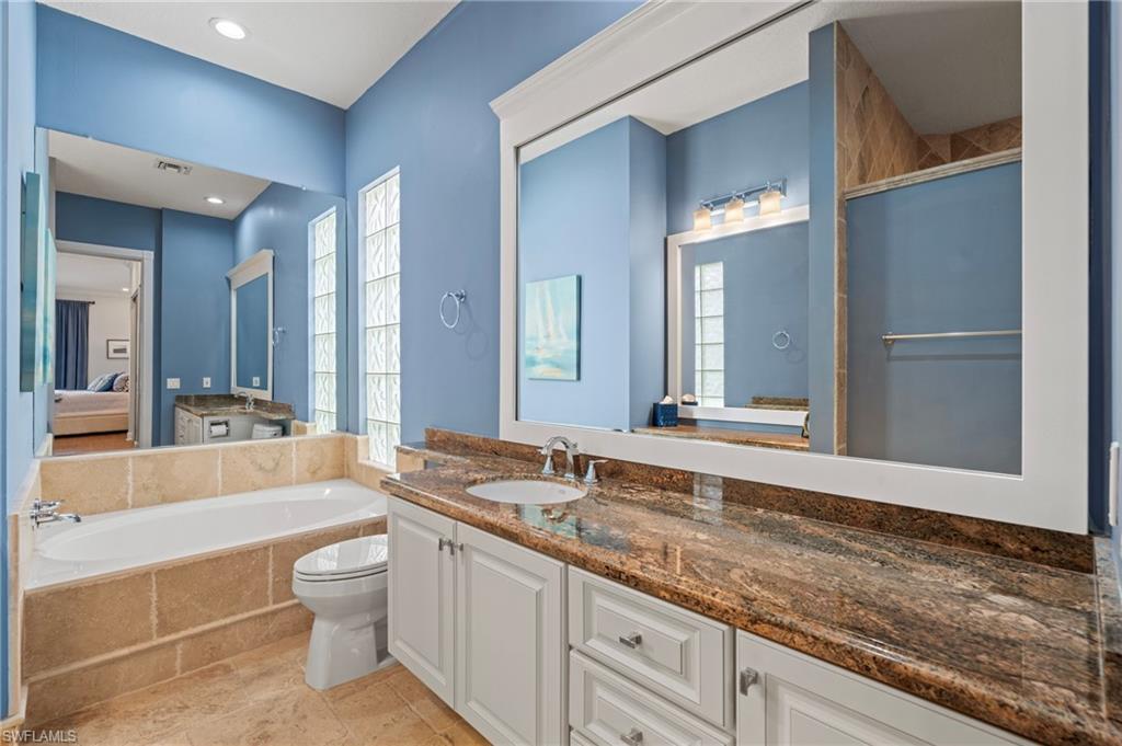 4401 Novato Court Naples, FL 34109 - Photo 27 of 50 a bathroom with a granite countertop sink mirror bathtub and toilet