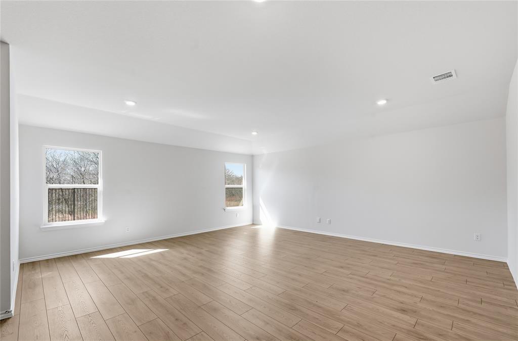 1907 Reveille Way Terrell, TX 75160 - Photo 4 of 6 Spacious interior room featuring light wood-finish flooring, recessed lighting, and multiple windows providing natural illumination