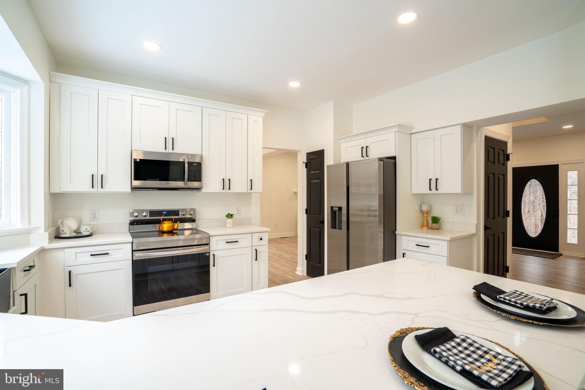 8261 Tinsley Place Culpeper, VA 22701 - Photo 15 of 80 a kitchen with stainless steel appliances kitchen island granite countertop a refrigerator sink and stove