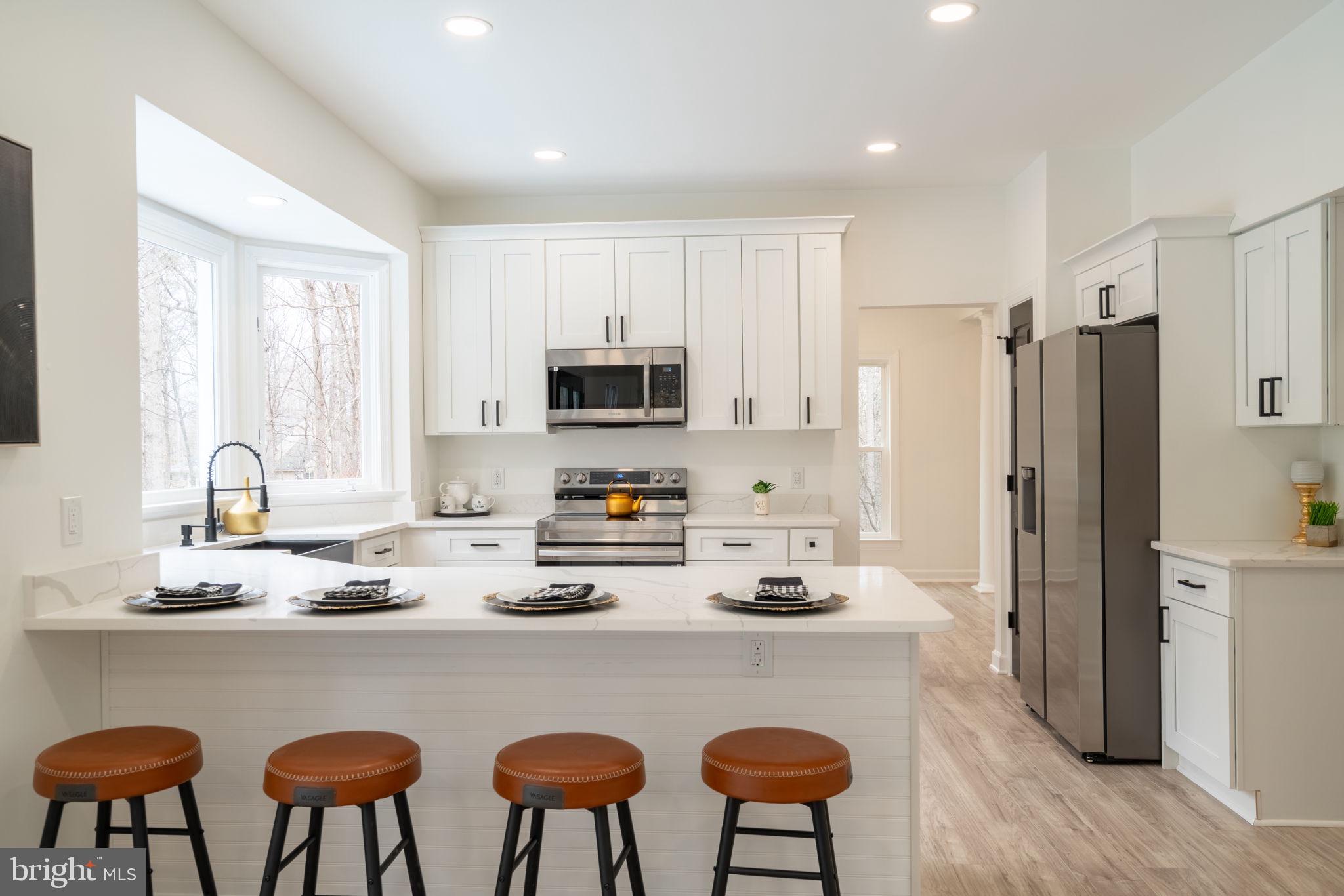 8261 Tinsley Place Culpeper, VA 22701 - Photo 17 of 80 a kitchen with stainless steel appliances granite countertop a refrigerator a stove a sink dishwasher and white cabinets with wooden floor