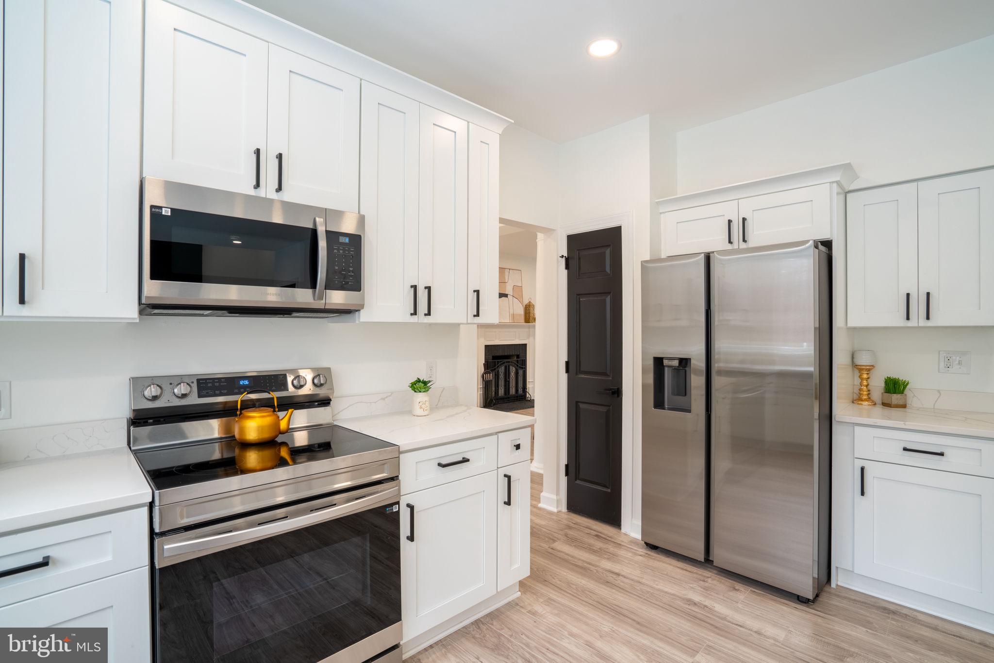 8261 Tinsley Place Culpeper, VA 22701 - Photo 19 of 80 a kitchen with stainless steel appliances a stove microwave and refrigerator
