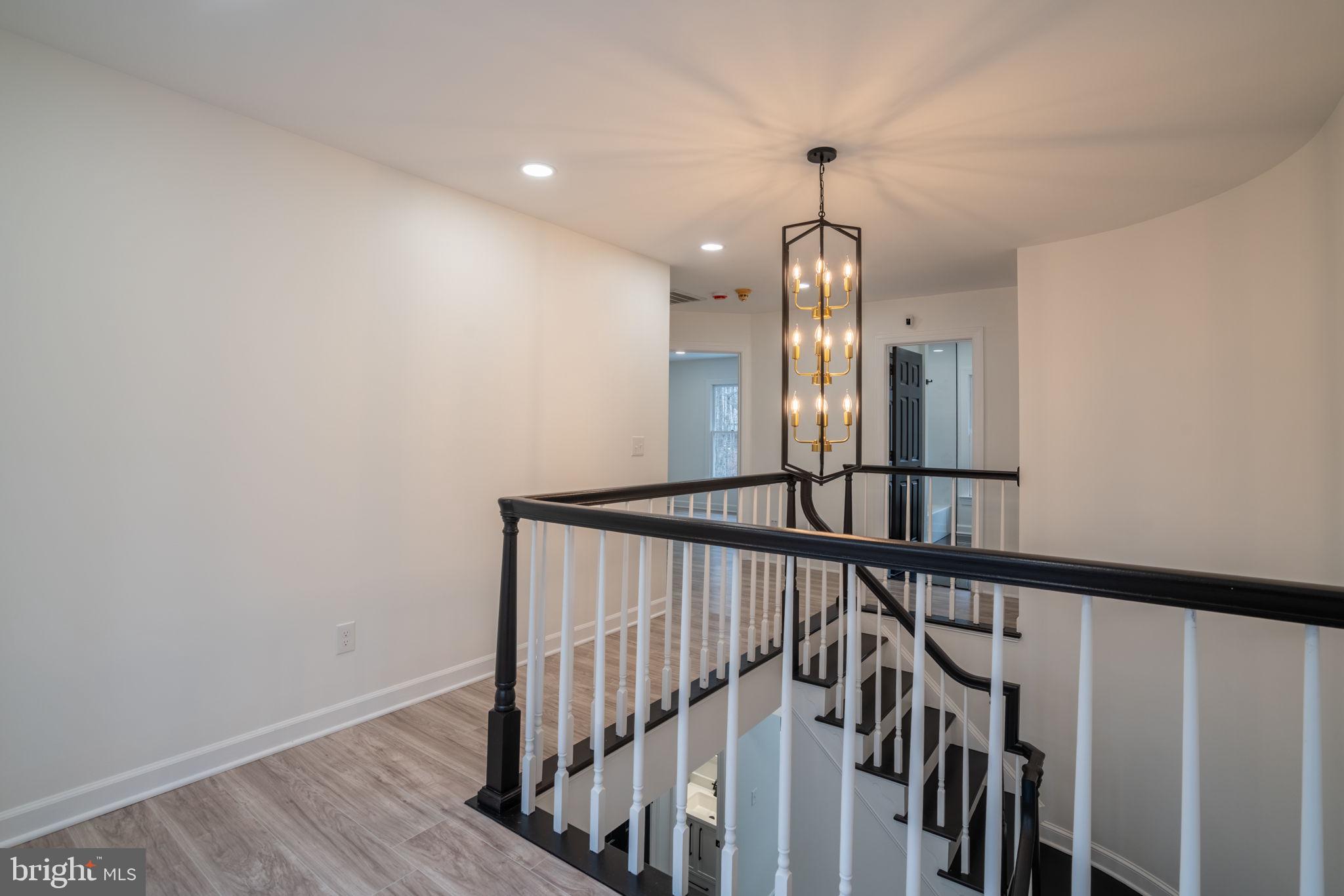 8261 Tinsley Place Culpeper, VA 22701 - Photo 34 of 80 a view of a hallway with wooden floor and stairs