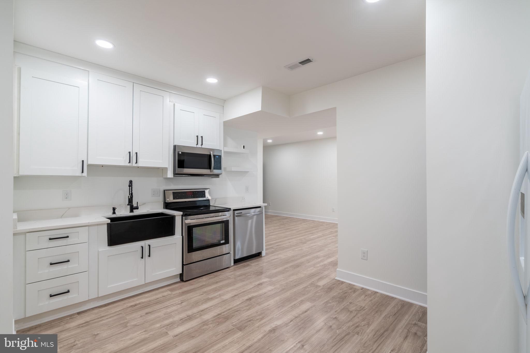 8261 Tinsley Place Culpeper, VA 22701 - Photo 58 of 80 a kitchen with granite countertop white cabinets and stainless steel appliances