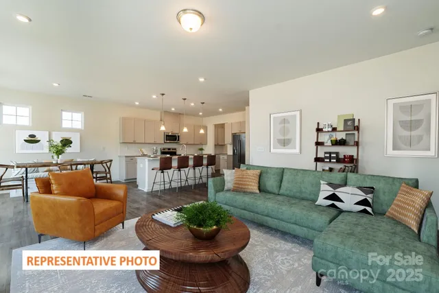 a living room with furniture and a view of kitchen