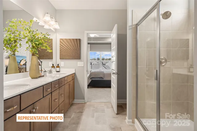 a en suite bathroom with a double vanity sink a mirror and a shower